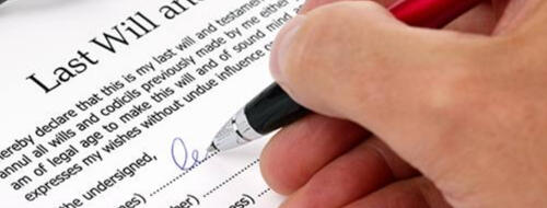 A person engaged in signing a last will and testament which was translated and court-certified into Italian for the donation of an estate in Tuscany.