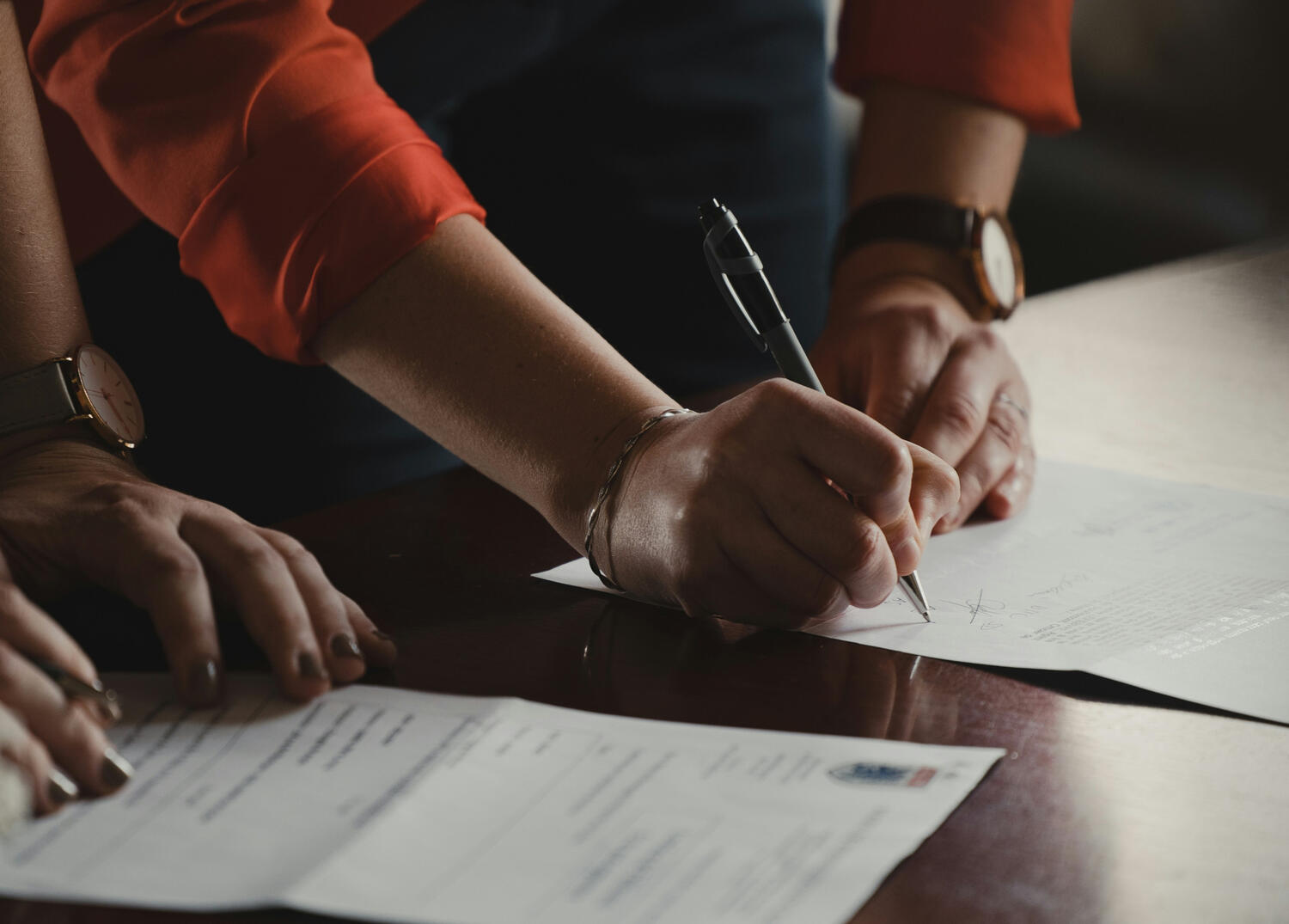 A close-up of a translator's hand signing the sworn statement for a certified translation before a court official in Florence Italy.