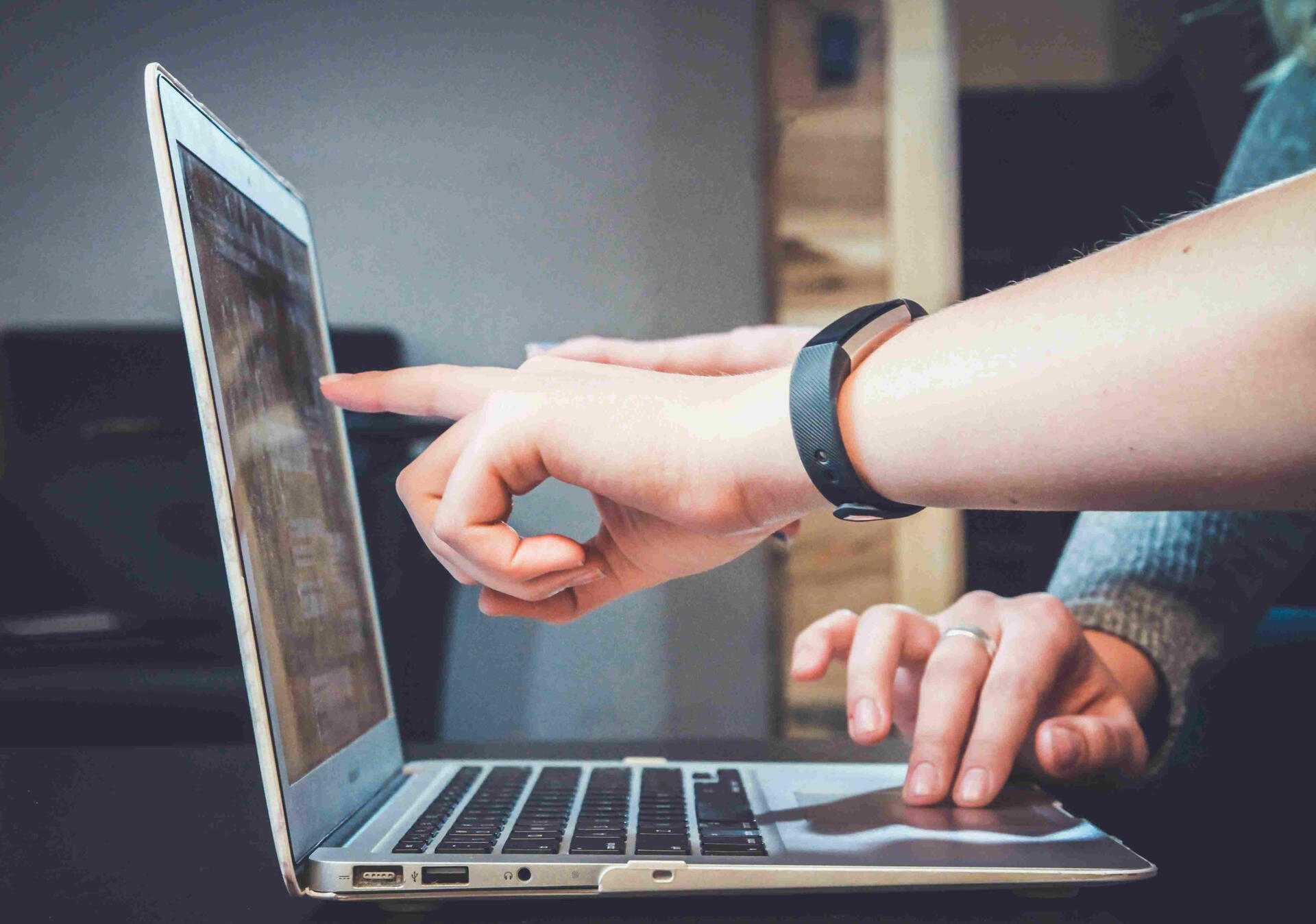 A professional reviewing a CV on a laptop to tailor it for the Italian job market during a coaching session.